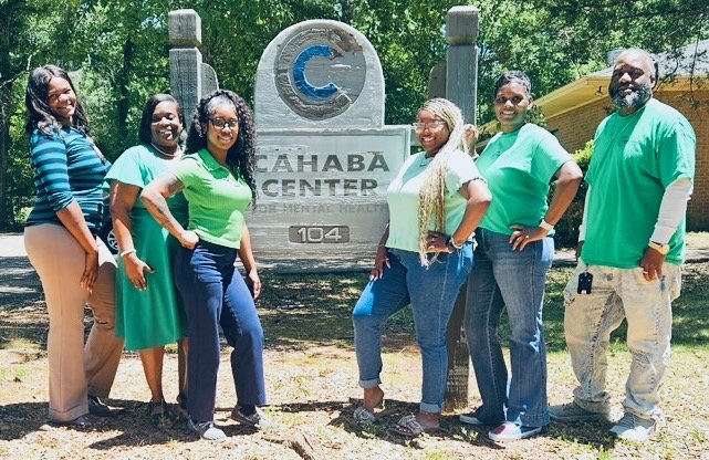 Cahaba Center for Mental Health staff in front of the Cahaba Center sign